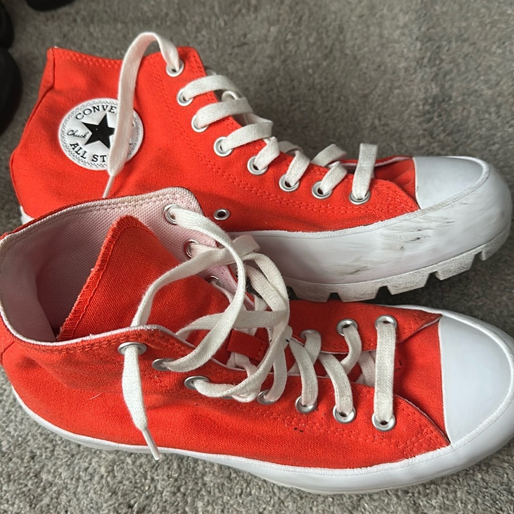 Woman’s used orange converse high tops